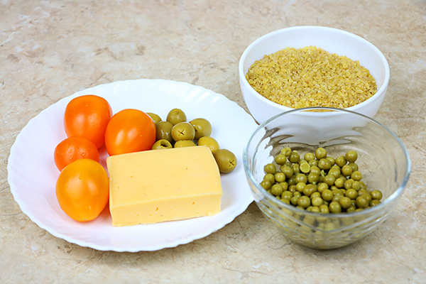 Поживний салат з булгуром, зеленим горошком, оливками, томатами та твердим сиром